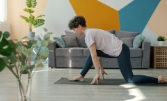 Flexible young woman is doing yoga in house practising asanas alone on comfy mat enjoying useful activity. Indoor sports, active lifestyle and modern youth concept.